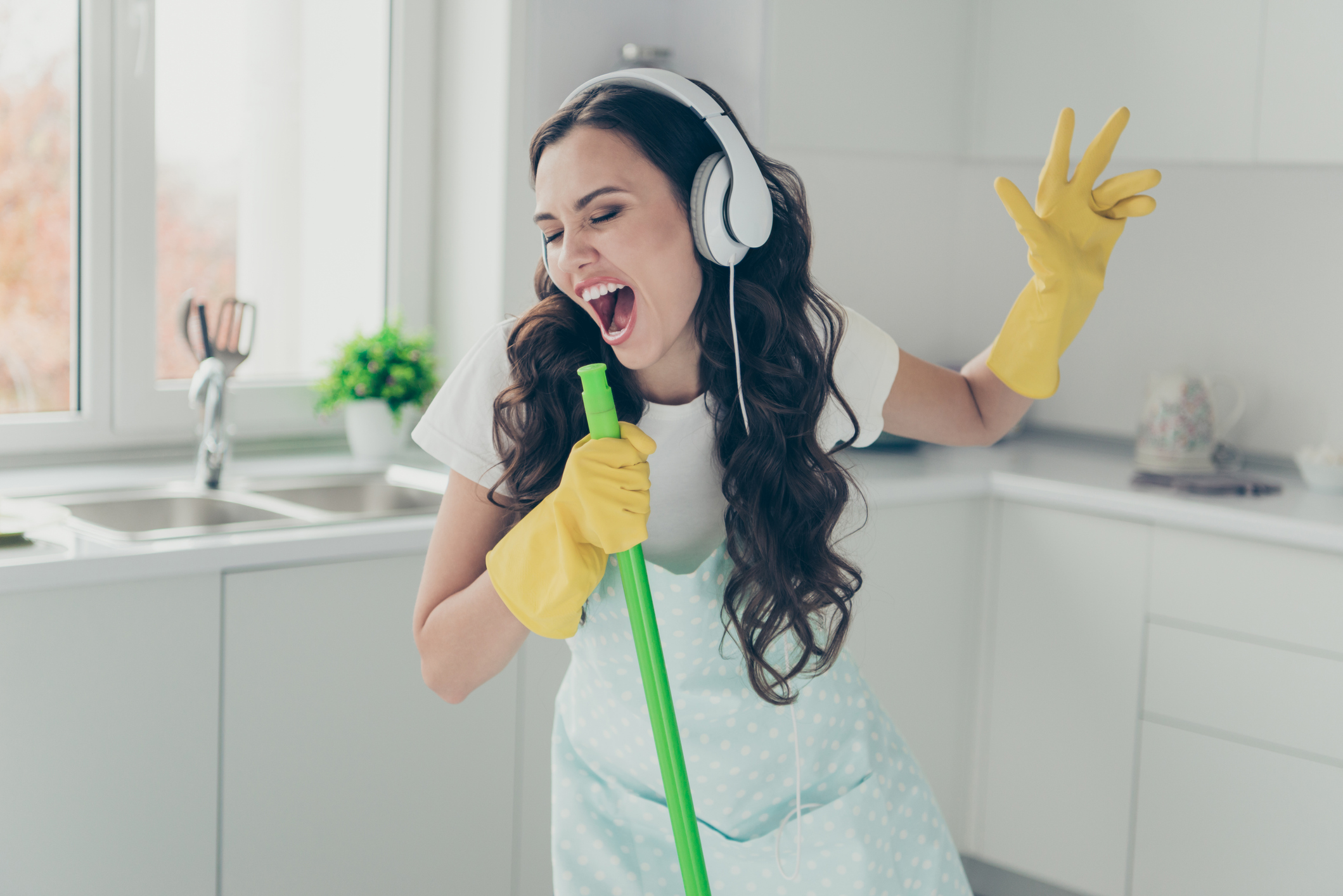 5 No Big Deal Cleaning Blog Post with lady holding mop and singing while cleaning